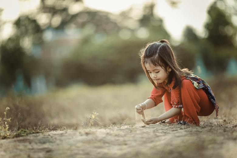 A little girl playing with sand