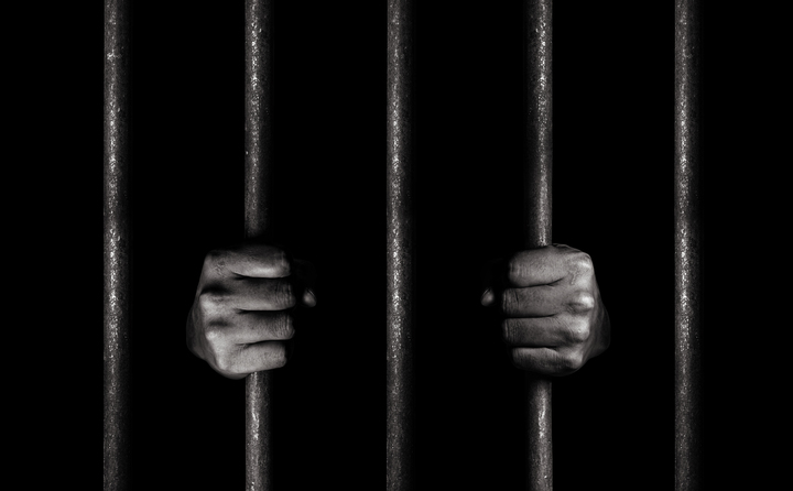 man behind bars showing criminal accountability