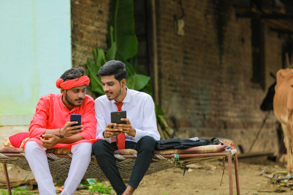 Two-young-men-in-countryside-using-mobile-phones-technology